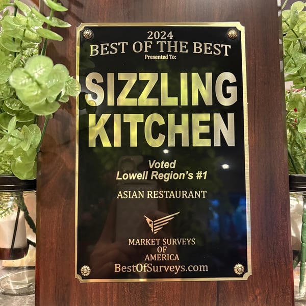 A plaque awarded to Sizzling Kitchen for "Best of the Best 2024" and "Lowell Region's #1 Asian Restaurant".