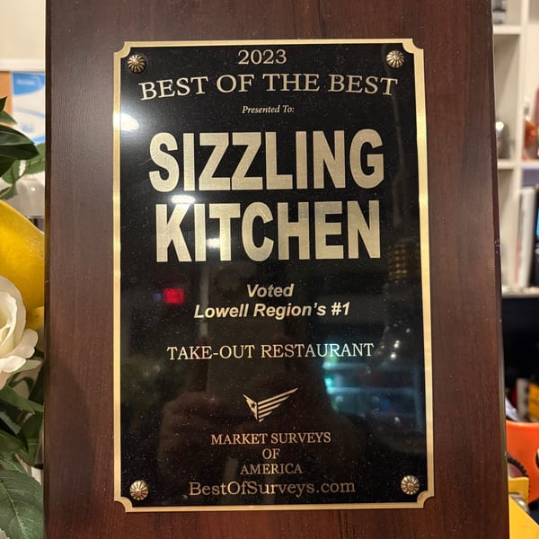 A plaque awarded to Sizzling Kitchen for "Best Take-Out Restaurant" in the Lowell Region for 2023.