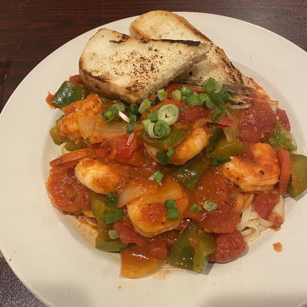 Sizzling Kitchen's shrimp and vegetable stir-fry with noodles, topped with scallions and toasted bread.